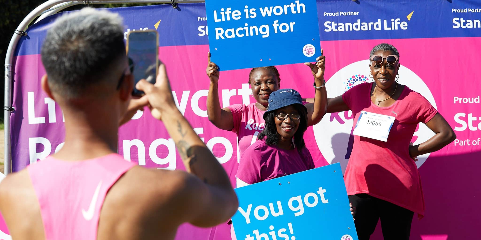 Group of three women getting there picture taken by another participant.